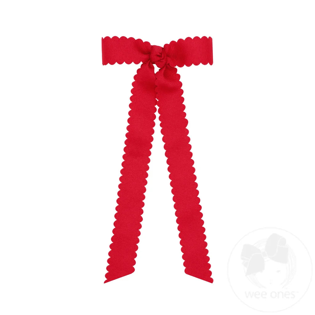 Pajarita pequeña de grosgrain con borde festoneado, nudo envolvente y cintas decorativas.
